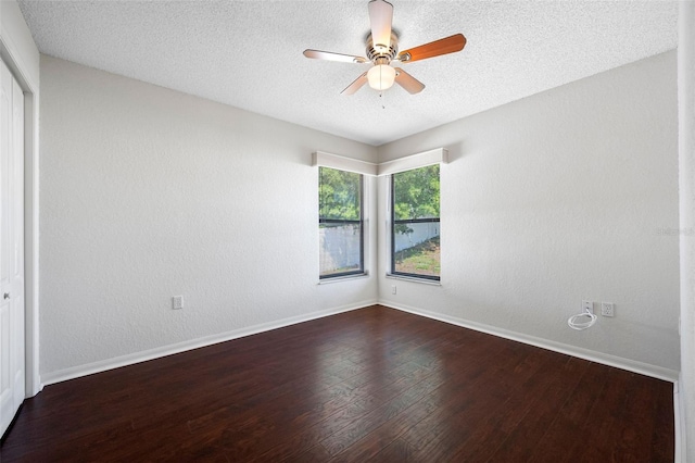 empty room with baseboards, a ceiling fan, wood finished floors, and a textured ceiling