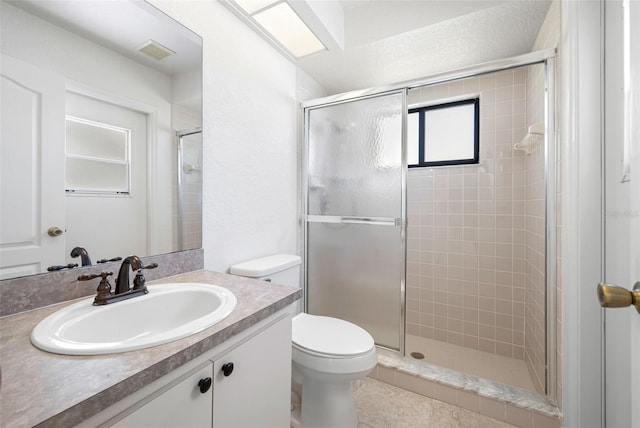 full bathroom featuring toilet, a stall shower, vanity, and visible vents