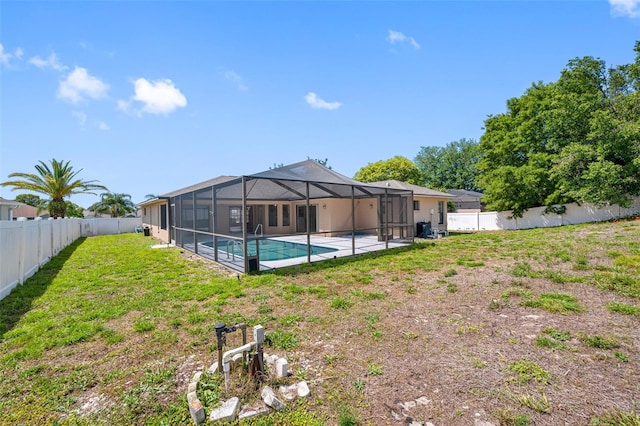 view of swimming pool with a yard, a fenced backyard, glass enclosure, a patio area, and a fenced in pool