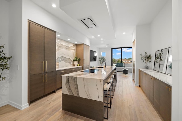 98 W Davis Blvd, Tampa, FL 33606 - kitchen with light wood finished floors, a breakfast bar area, modern cabinets, and an island with sink
