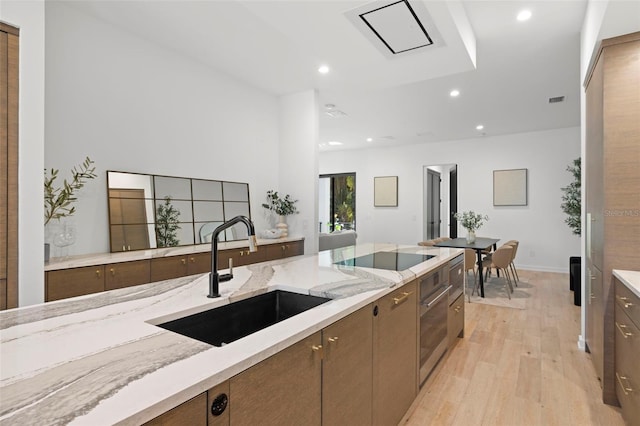98 W Davis Blvd, Tampa, FL 33606 - kitchen featuring light wood-style floors, recessed lighting, a sink, black electric stovetop, and oven