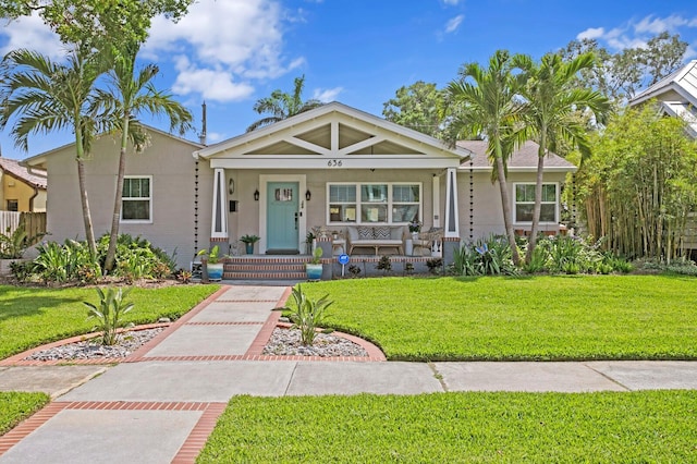 636 16th Ave NE, Saint Petersburg, FL 33704 - view of front facade with a front yard, a porch, and stucco siding