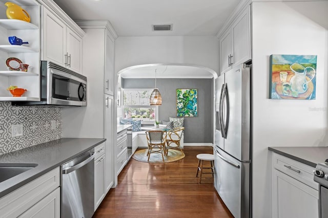 636 16th Ave NE, Saint Petersburg, FL 33704 - kitchen featuring visible vents, open shelves, dark countertops, dark wood finished floors, and stainless steel appliances