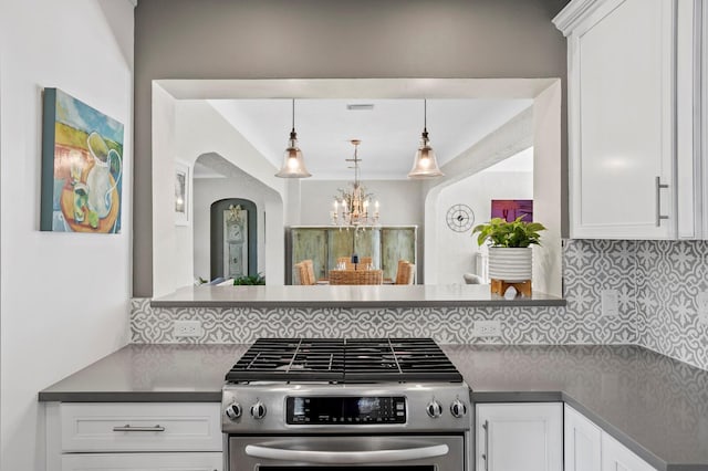 636 16th Ave NE, Saint Petersburg, FL 33704 - kitchen with tasteful backsplash, gas range, dark countertops, and white cabinetry