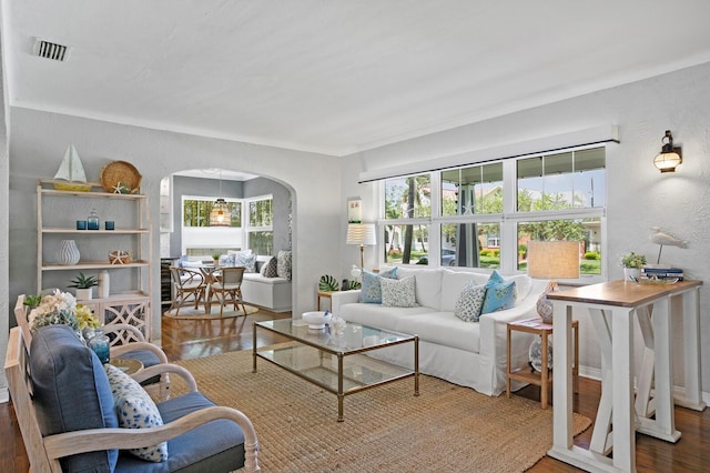 636 16th Ave NE, Saint Petersburg, FL 33704 - living room featuring arched walkways, wood finished floors, a textured wall, and a wealth of natural light