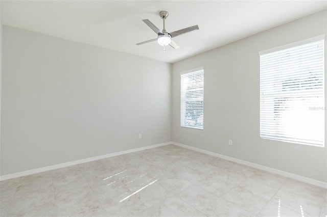 unfurnished room featuring ceiling fan and baseboards