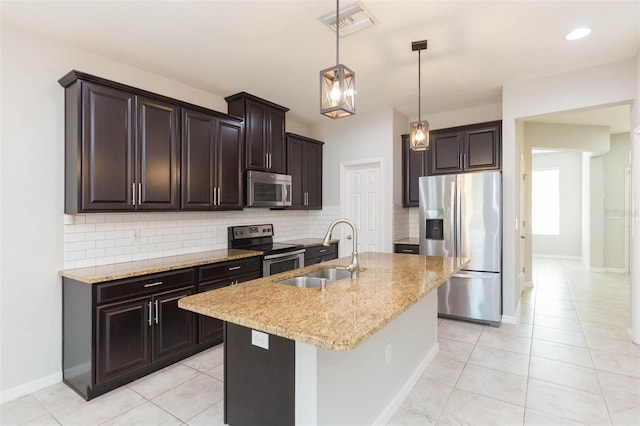 kitchen with decorative backsplash, a sink, light stone counters, and appliances with stainless steel finishes