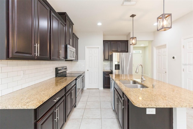 kitchen featuring backsplash, dark brown cabinets, visible vents, stainless steel appliances, and a sink