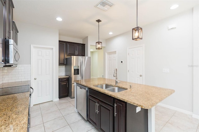 kitchen featuring light tile patterned floors, decorative light fixtures, a sink, stainless steel appliances, and decorative backsplash