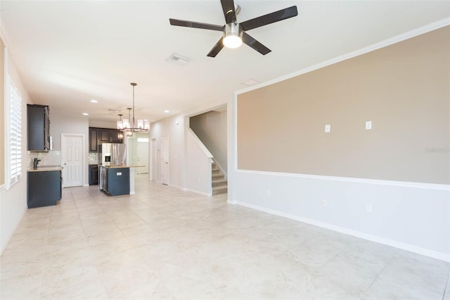 unfurnished living room with baseboards, recessed lighting, stairway, visible vents, and ceiling fan with notable chandelier