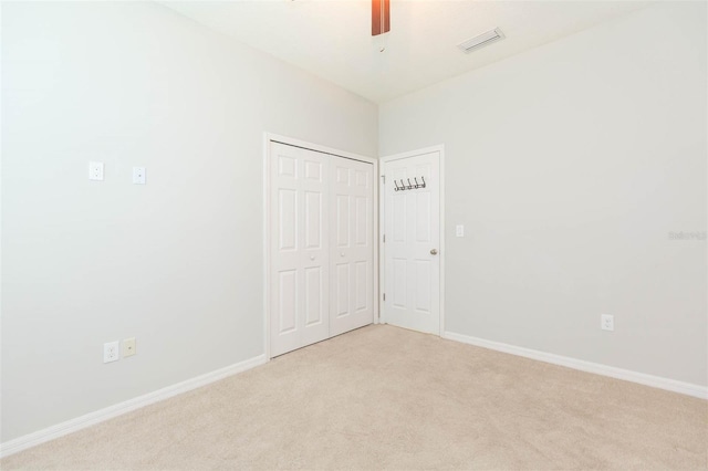 spare room featuring light colored carpet, baseboards, and visible vents