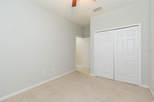 unfurnished bedroom featuring ceiling fan, a closet, visible vents, carpet flooring, and baseboards