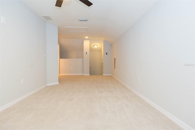 spare room with visible vents, ceiling fan, attic access, light carpet, and lofted ceiling