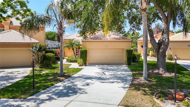 view of front of home featuring a tiled roof, a garage, stucco siding, a front yard, and concrete driveway