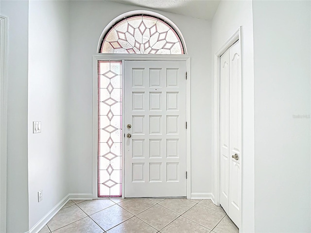foyer entrance featuring light tile patterned floors and baseboards