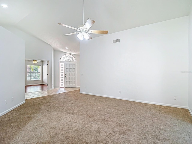 spare room with ceiling fan, visible vents, carpet floors, lofted ceiling, and baseboards