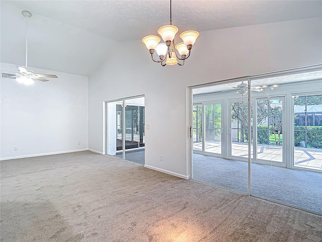 empty room with a healthy amount of sunlight, high vaulted ceiling, and ceiling fan with notable chandelier