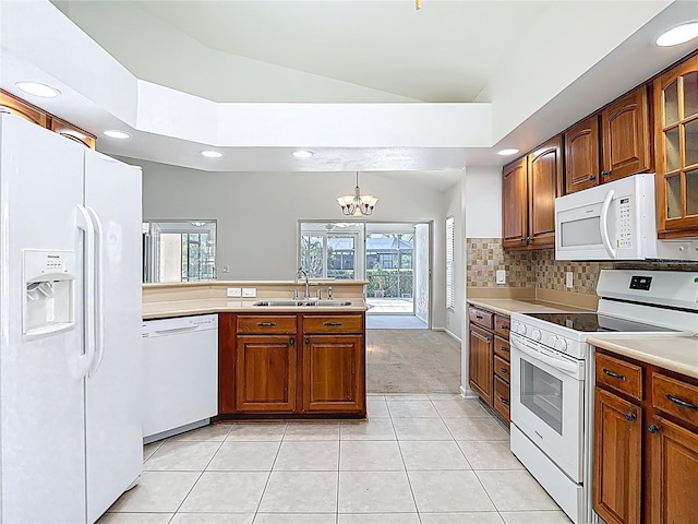 kitchen featuring light tile patterned floors, white appliances, a peninsula, a sink, and lofted ceiling