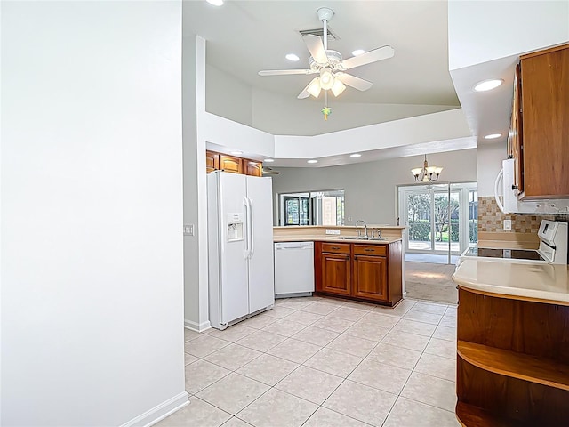 kitchen featuring white appliances, a peninsula, brown cabinets, recessed lighting, and light tile patterned flooring