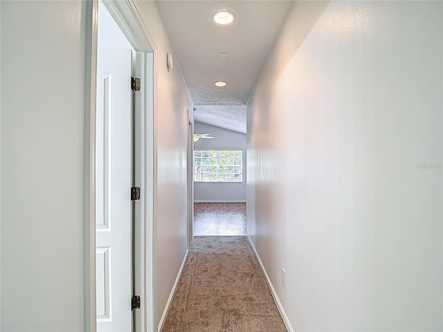 hall with baseboards, recessed lighting, carpet, and lofted ceiling