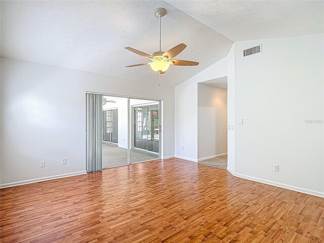 unfurnished room with baseboards, light wood-style flooring, a textured ceiling, a ceiling fan, and visible vents
