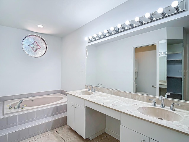 full bathroom featuring tile patterned floors, double vanity, a bath, and a sink