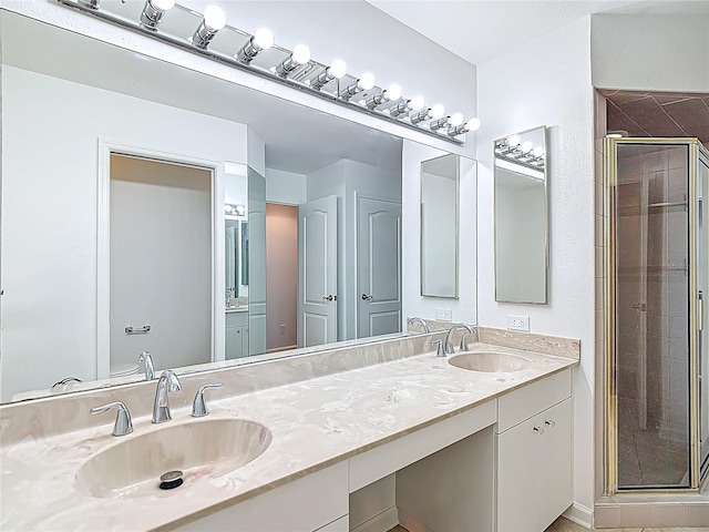 bathroom with double vanity, a sink, and a stall shower