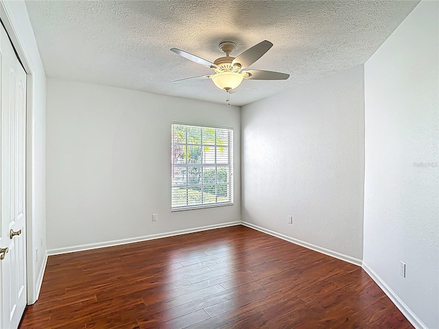 spare room featuring a textured ceiling, baseboards, a ceiling fan, and wood finished floors