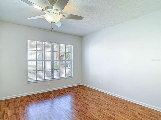 empty room featuring ceiling fan, a textured ceiling, and wood finished floors