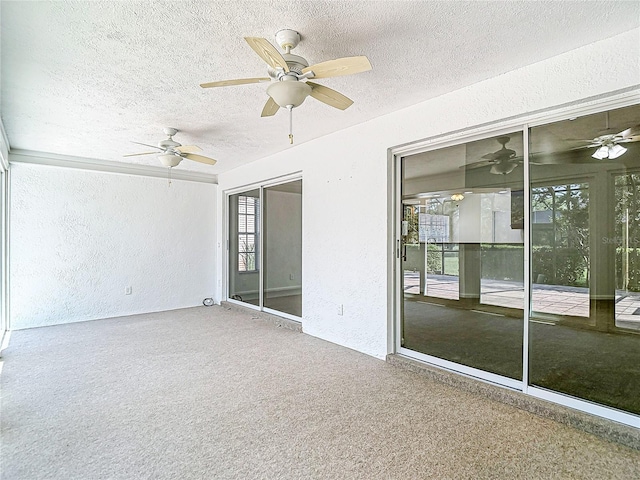 empty room with ceiling fan, a textured wall, and a textured ceiling