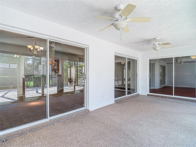 unfurnished sunroom with ceiling fan with notable chandelier