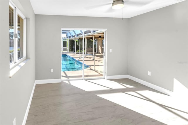 6994 Country Lakes Cir, Sarasota, FL 34243 - empty room featuring ceiling fan, a sunroom, and marble finish flooring