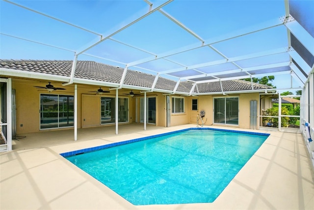 6994 Country Lakes Cir, Sarasota, FL 34243 - back of house featuring a tiled roof, ceiling fan, stucco siding, a patio area, and an outdoor pool