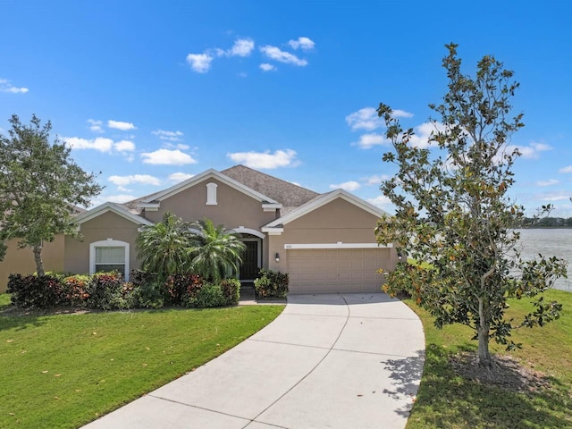 view of front facade featuring a garage, stucco siding, driveway, and a front yard