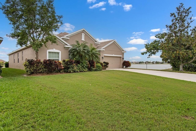 view of front of property featuring a front yard, an attached garage, stucco siding, and concrete driveway