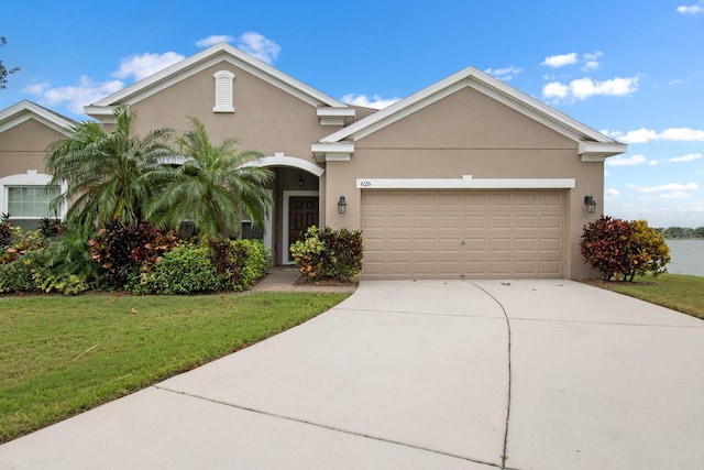 view of front of property featuring a front yard, driveway, stucco siding, and an attached garage