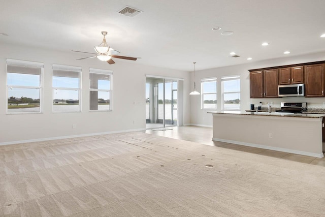 kitchen with open floor plan, appliances with stainless steel finishes, and light colored carpet