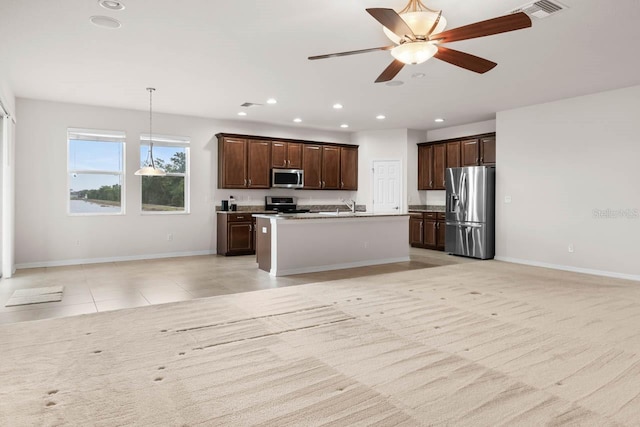 kitchen with baseboards, open floor plan, appliances with stainless steel finishes, dark brown cabinets, and recessed lighting