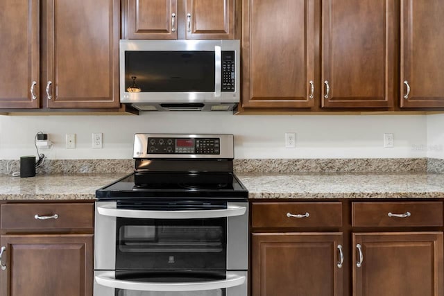kitchen featuring light stone countertops and stainless steel appliances