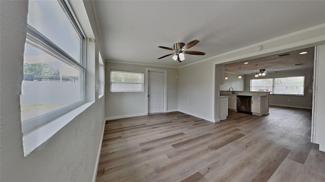 1835 Nevada Ave NE, Saint Petersburg, FL 33703 - unfurnished living room with light wood-style flooring, a healthy amount of sunlight, ornamental molding, and a ceiling fan