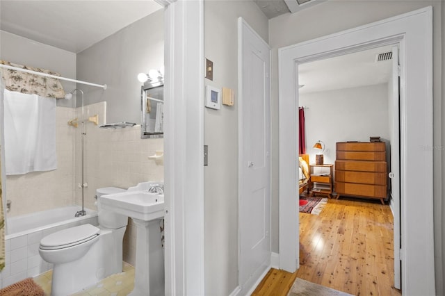 3120 8th Ave N, Saint Petersburg, FL 33713 - full bath featuring tiled shower / bath, toilet, and wood finished floors
