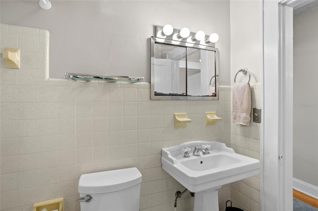 3120 8th Ave N, Saint Petersburg, FL 33713 - half bathroom with toilet, tile walls, a sink, and wainscoting