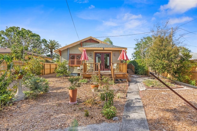 3120 8th Ave N, Saint Petersburg, FL 33713 - view of front of house with french doors, a wooden deck, a fenced backyard, and a garden