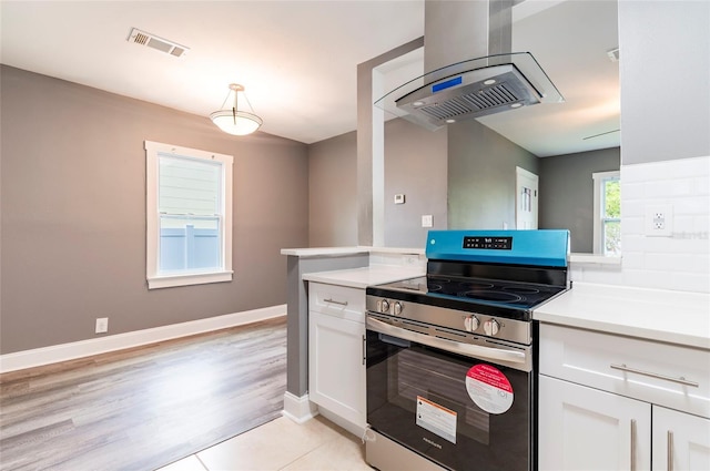 2017 Oceanview Pl, Tampa, FL 33605 - kitchen with visible vents, white cabinets, extractor fan, and stainless steel electric range oven