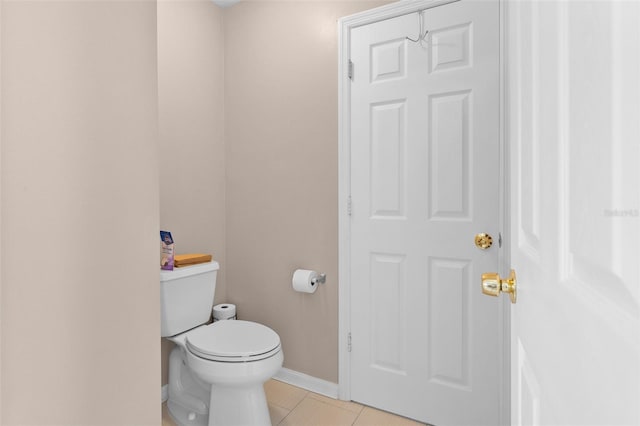 bathroom with baseboards, tile patterned floors, and toilet