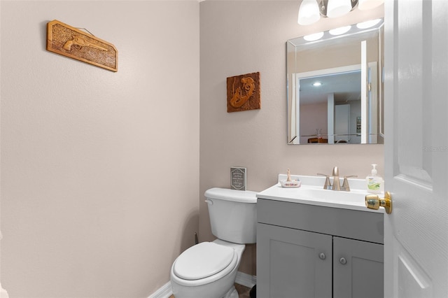 bathroom featuring vanity, toilet, and baseboards