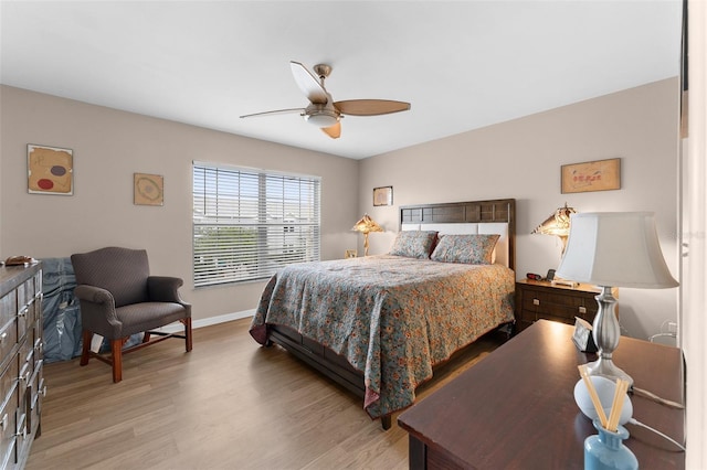 bedroom with wood finished floors, a ceiling fan, and baseboards
