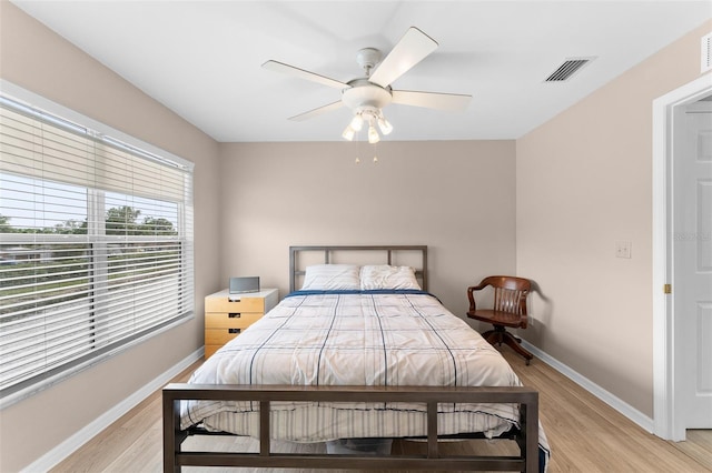 bedroom featuring light wood finished floors, baseboards, and a ceiling fan