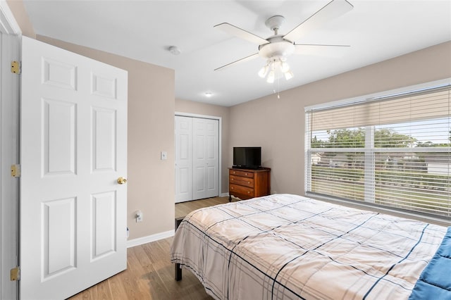 bedroom with light wood finished floors, baseboards, a closet, and ceiling fan