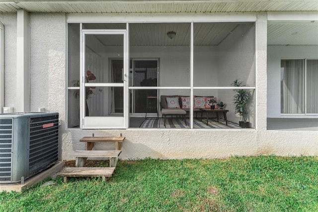 entrance to property featuring central air condition unit and stucco siding